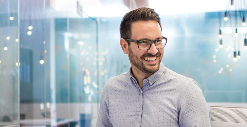 Ein Mann mit Brille lacht