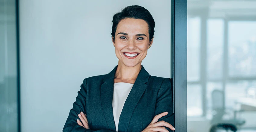 Eine Frau mit verschränkten Armen lächelt