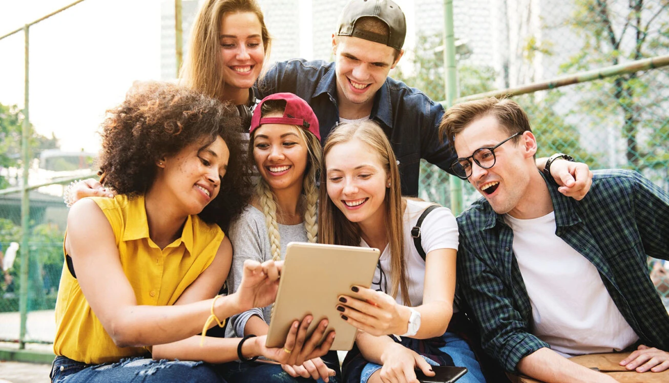 Eine Gruppe von Menschen schauen gemeinsam auf ein Tablet